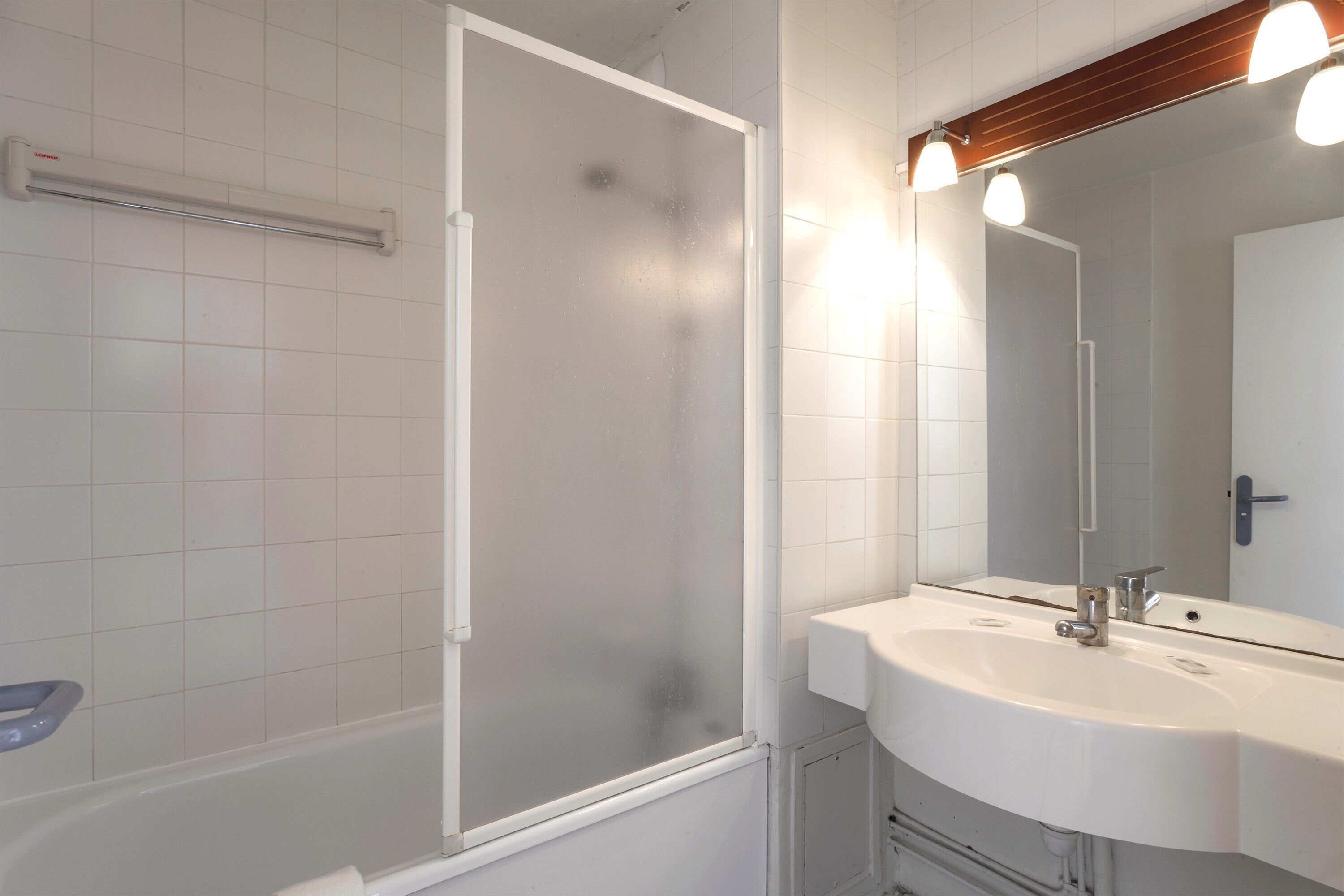 Baño con ducha, lavabo y espejo.
