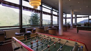 A room with a foosball table, large windows with a view of mountains, and a pool table. - Belambra Clubs Les Menuires - Neige Et Ciel (Les Belleville)