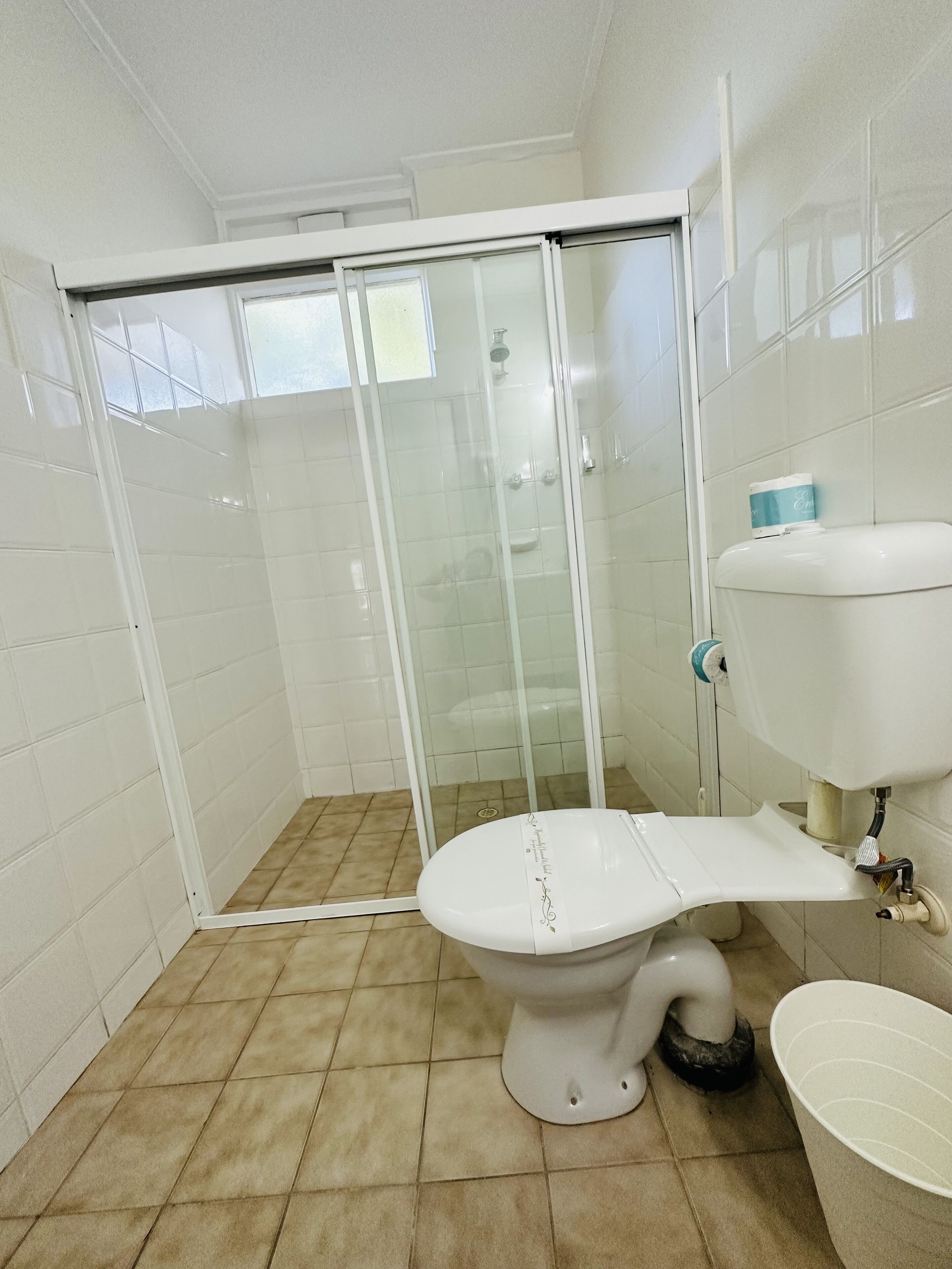 A bathroom with a toilet, a shower enclosure, and a bidet.