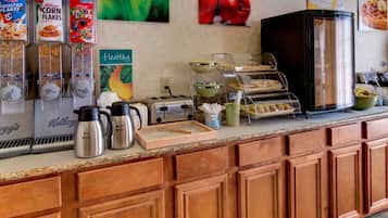 Un comptoir de petit-déjeuner avec divers aliments, une machine à café, un grille-pain et un réfrigérateur.