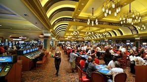 A casino with multiple gaming tables and slot machines, a patterned carpet, and a chandelier. - South Point Hotel, Casino, and Spa (Las Vegas)
