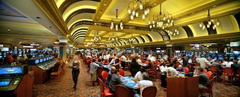 A hotel lobby with a long reception desk, ornate chandeliers, and a large decorative floor pattern. at South Point Hotel, Casino, and Spa
