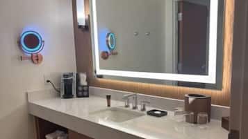 Uma casa de banho moderna com um espelho grande, duas pias e uma cómoda.