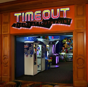 A gym with cardio machines, weight machines, and a TV screen. at South Point Hotel, Casino, and Spa