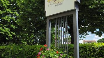 En skylt för Sittler Resort Hotel, med en stor blomlåda framför.