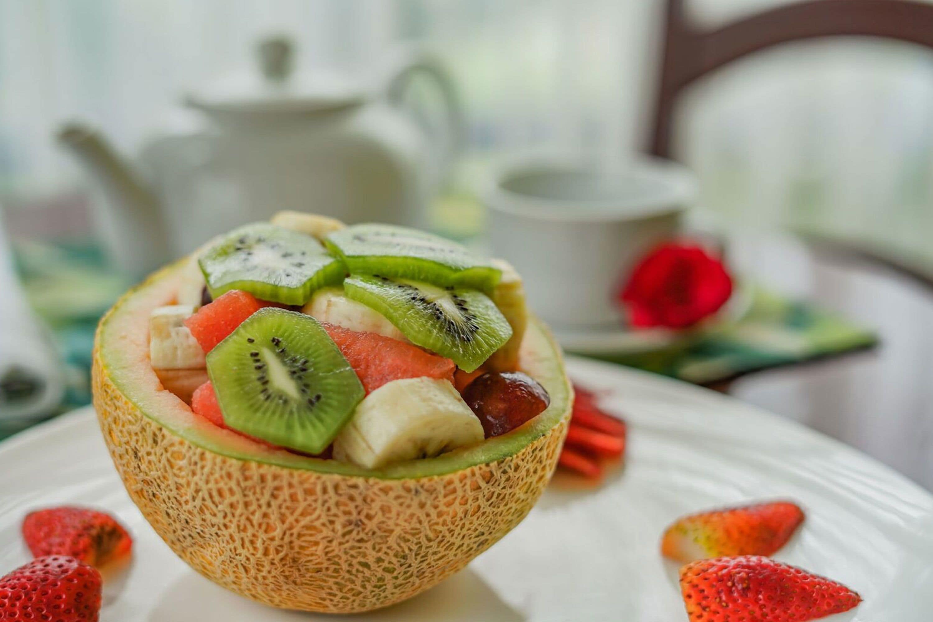 Un tazón de ensalada de frutas con fresas, sandía, kiwi y plátano.