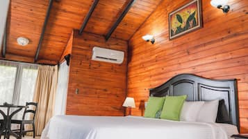Habitación con paneles de madera, una cama, una mesa y una silla.