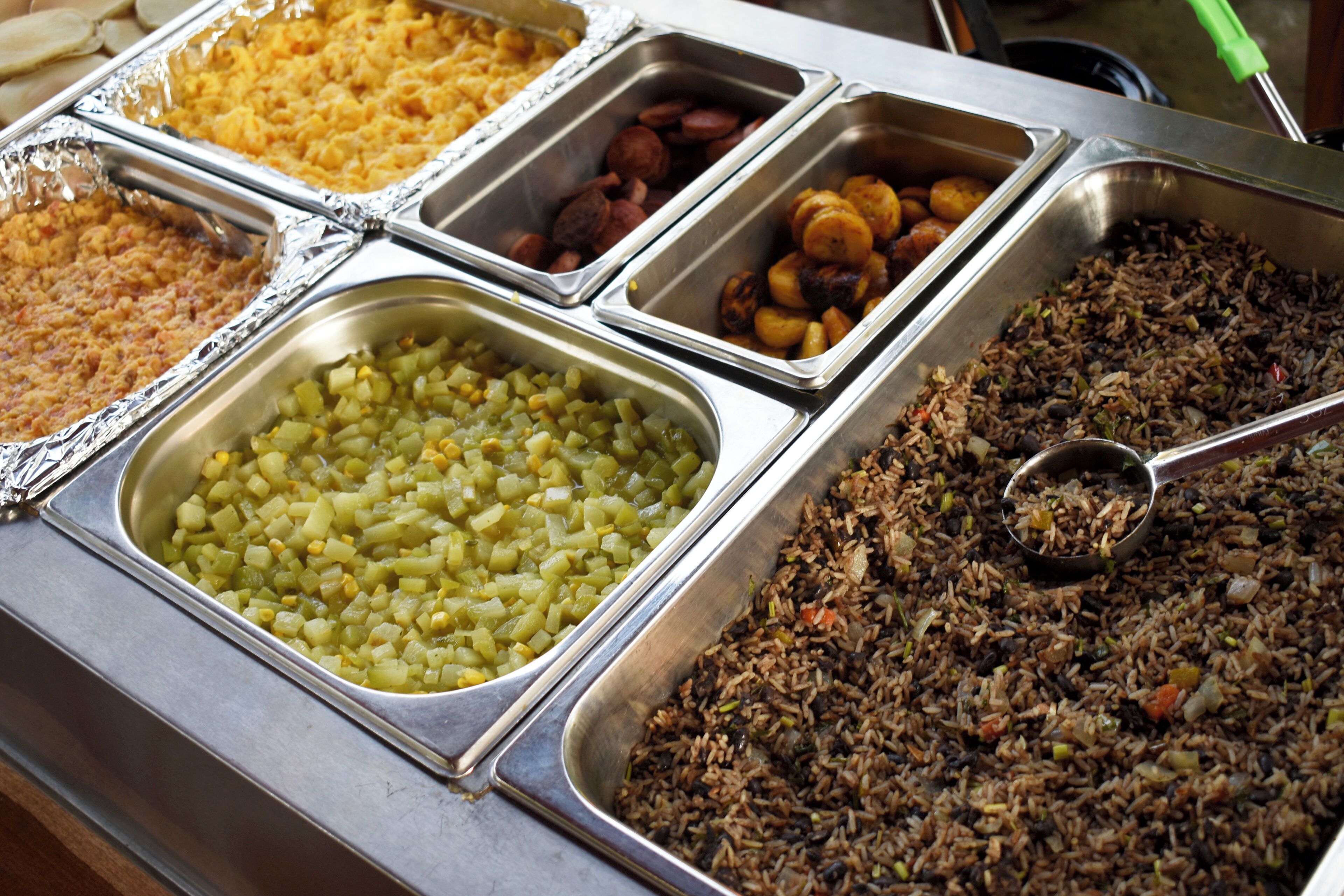 A buffet with various dishes including rice, vegetables, and meats.