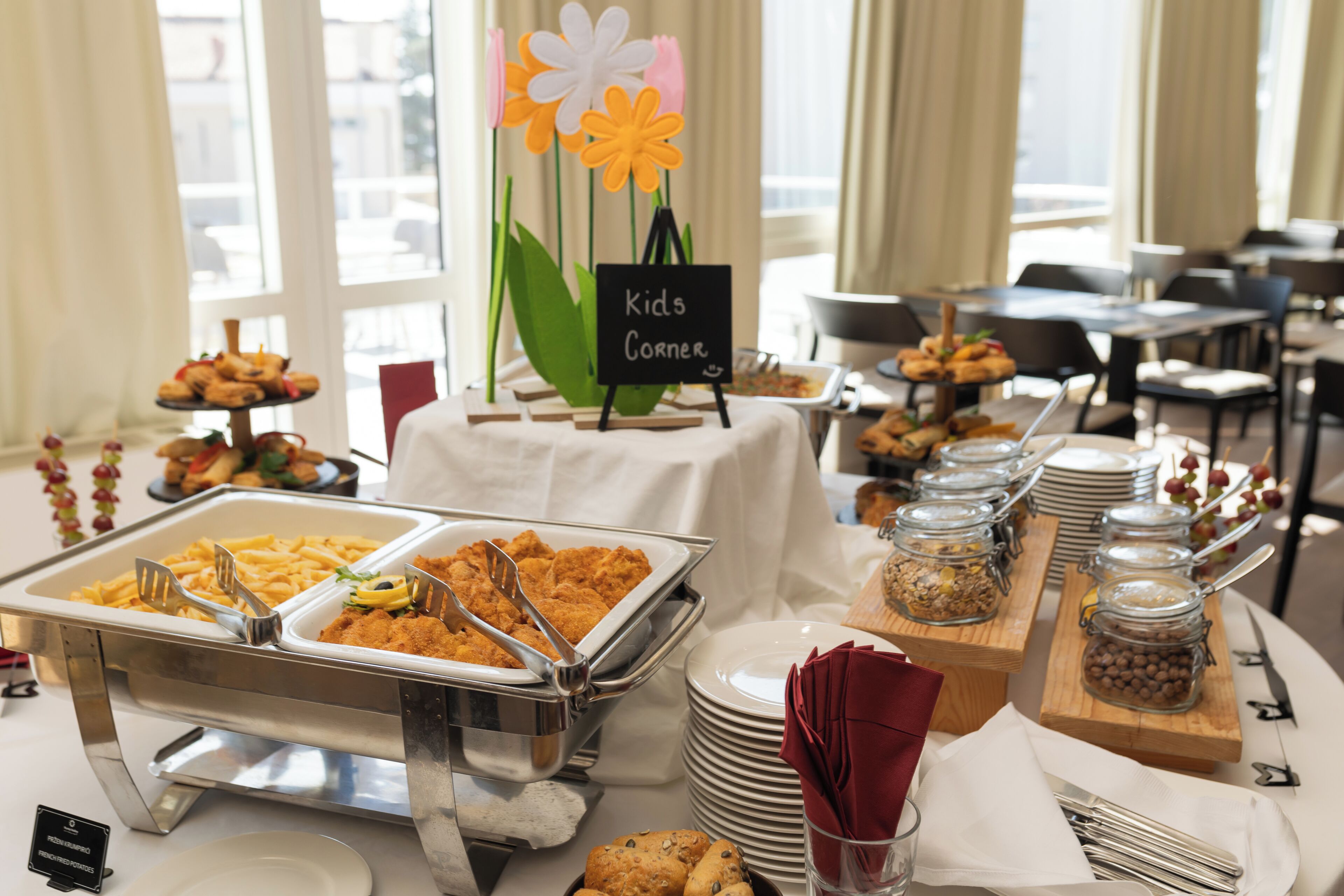 A buffet setup with labeled sections for kids and various food items.