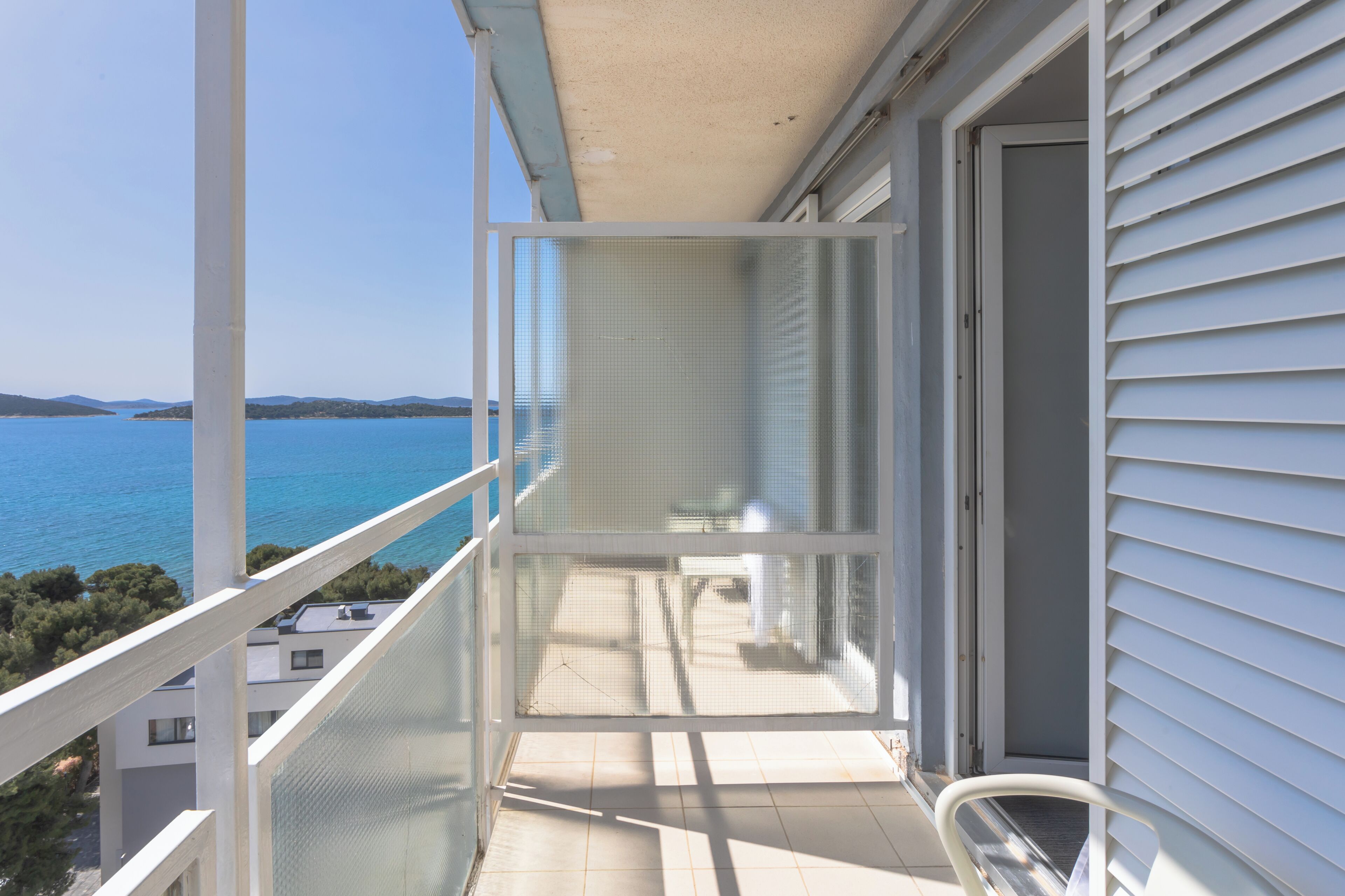 A balcony with a clear view of the sea and distant land.
