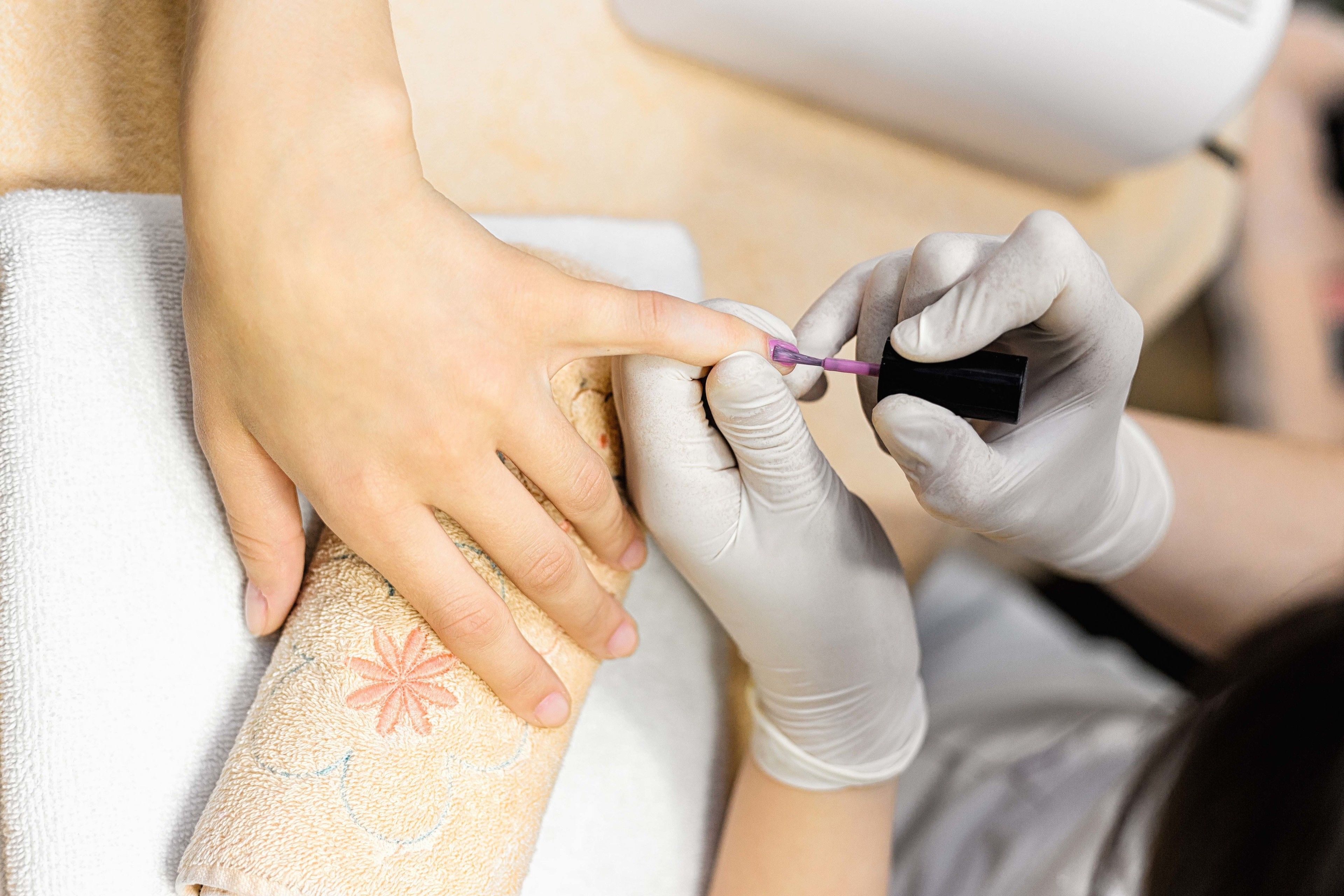 A close-up of a person receiving a manicure.