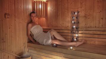 A sauna with wooden benches and a metal rack with candles.