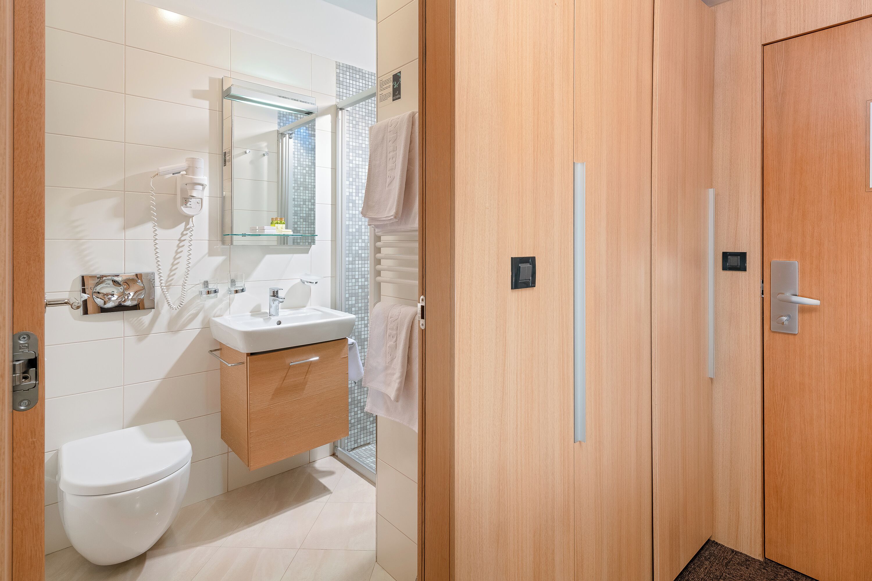 Un baño moderno con inodoro, lavamanos y ducha.