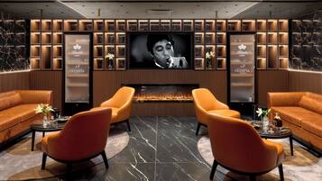 Een moderne zithoek met een grote flatscreen-tv, comfortabele zitplaatsen en een ingebouwde open haard.