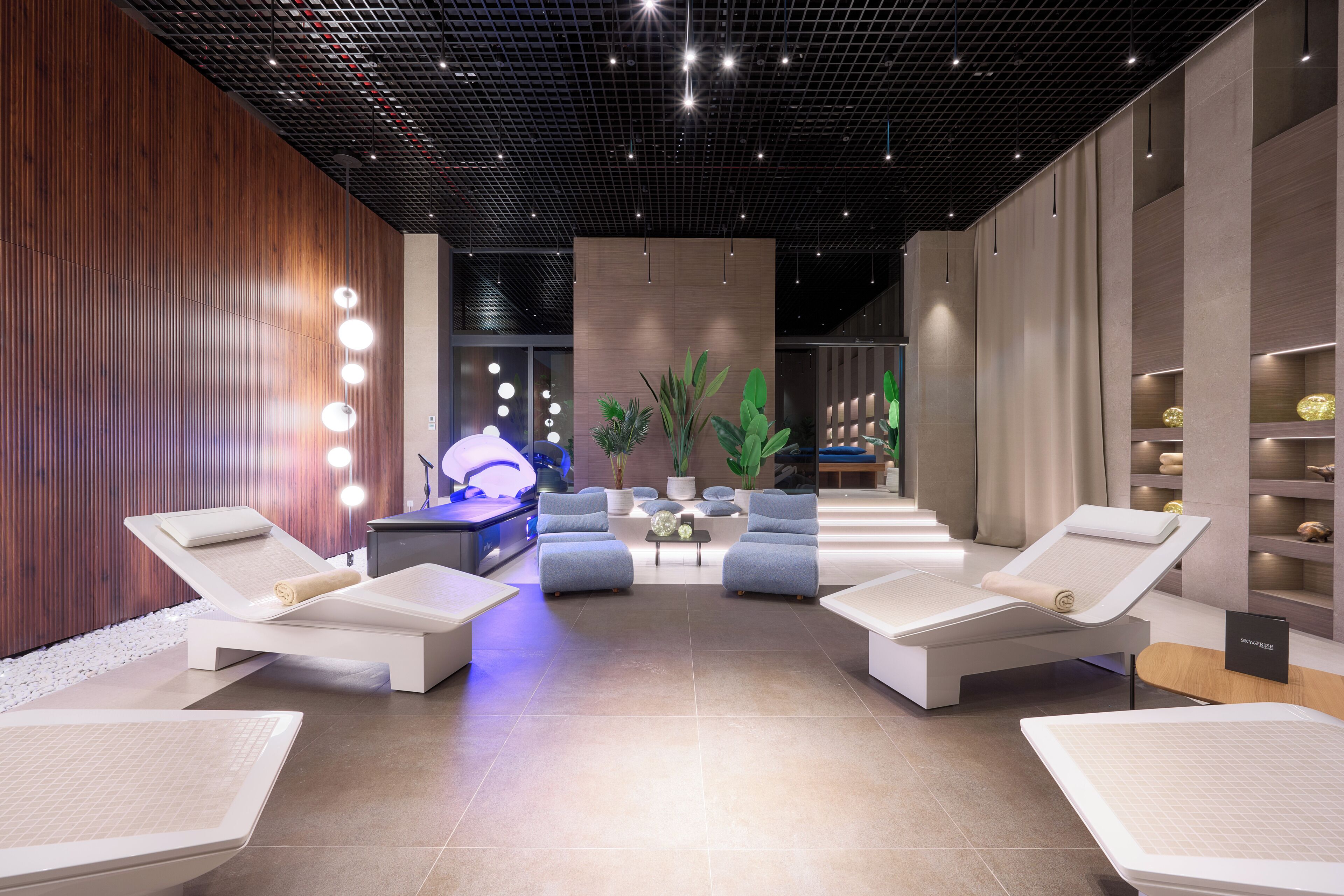 A modern spa area with lounge chairs, a massage table, and ambient lighting.