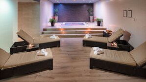 Un espacio de spa con dos sillones de descanso, una mesa de masajes y una piscina pequeña.