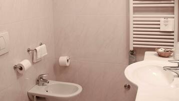 Un baño con inodoro, lavabo y bidé.