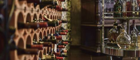 A wine rack with multiple bottles and a glass display case with bottles.