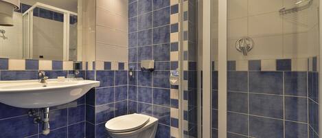 A bathroom with a sink, toilet, and shower.