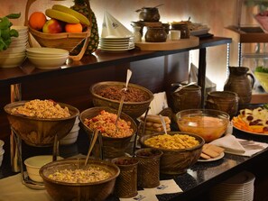 Un bufé con diversos alimentos y utensilios de servicio.