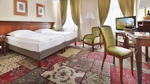 A hotel room with a bed, two chairs, a desk with a computer, and a TV. - EA Hotel Jelení dvůr Prague Castle (Prague)
