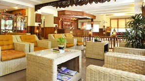 A lobby with wicker furniture, a reception desk, and a reception area. - City River Hotel (Siem Reap)
