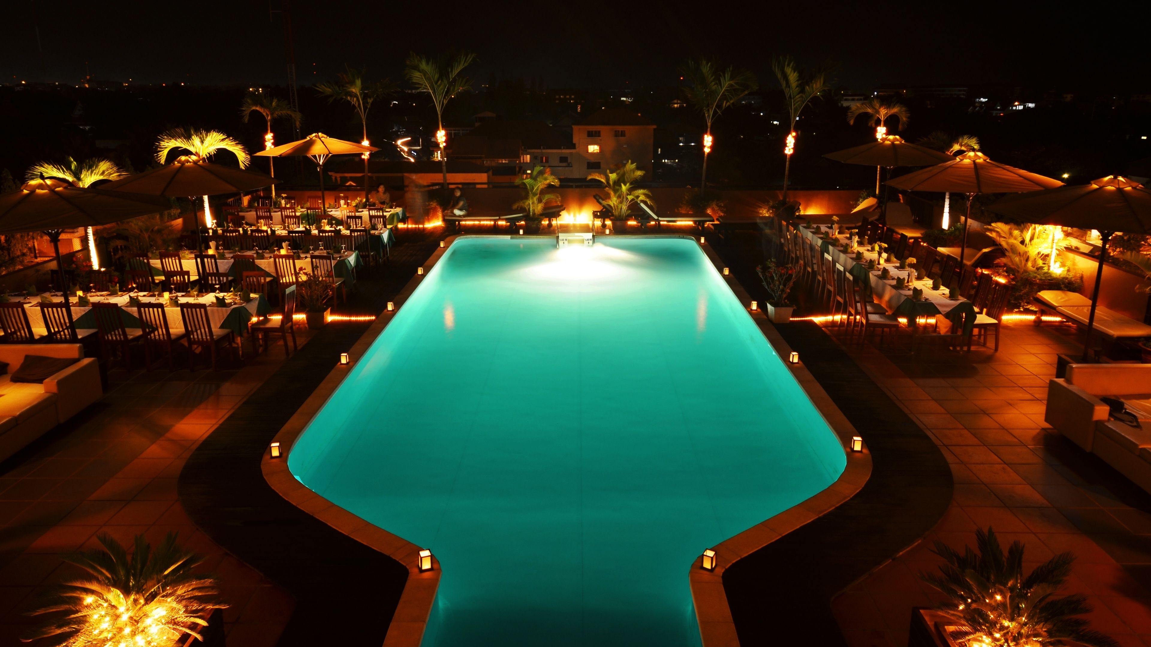 Una piscina al aire libre, sombrillas, tumbonas