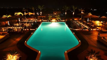 Una piscina al aire libre, sombrillas, tumbonas