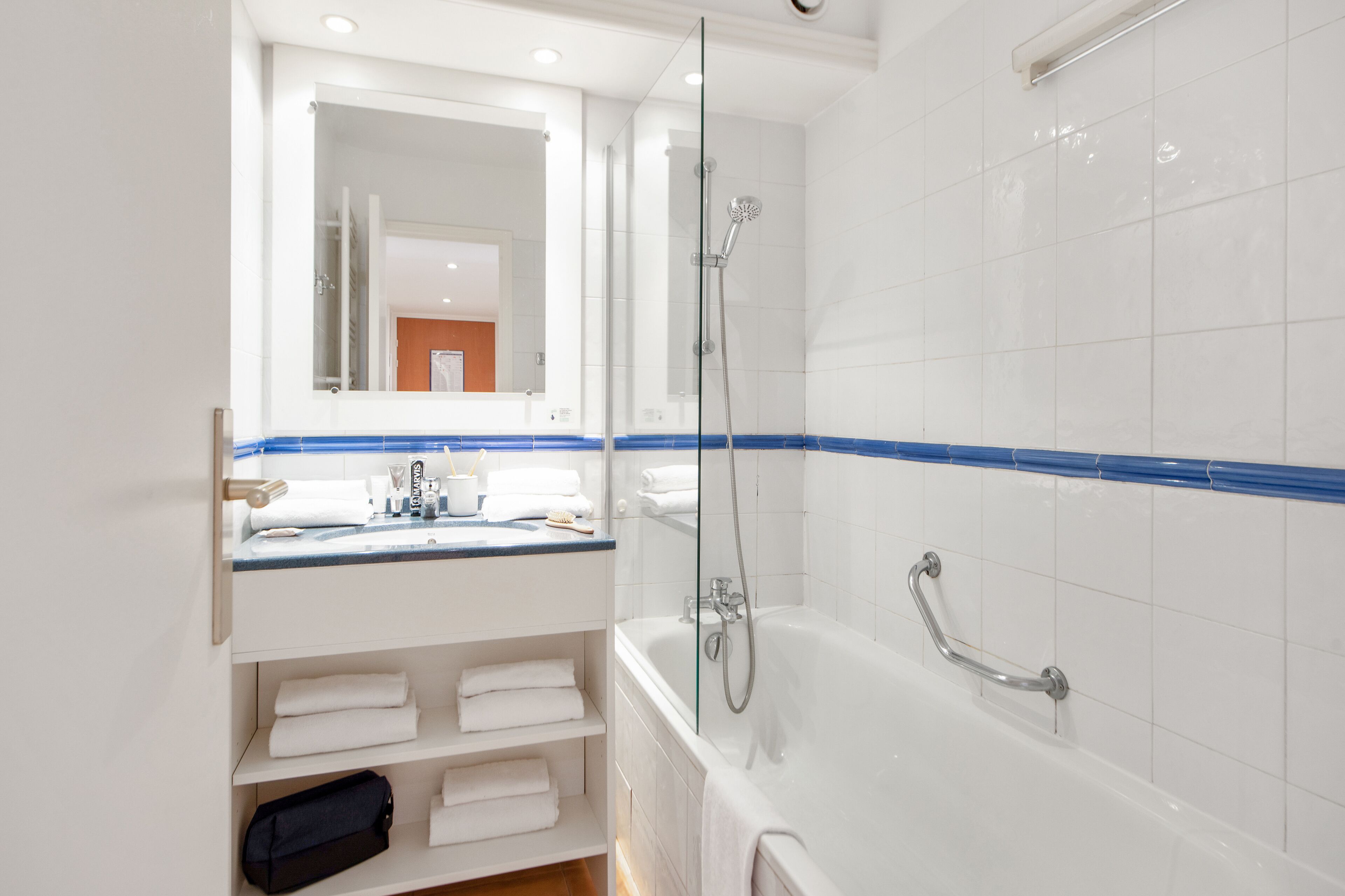 Une salle de bain moderne avec une douche à parois de verre, une baignoire blanche et un meuble-lavabo avec un miroir.