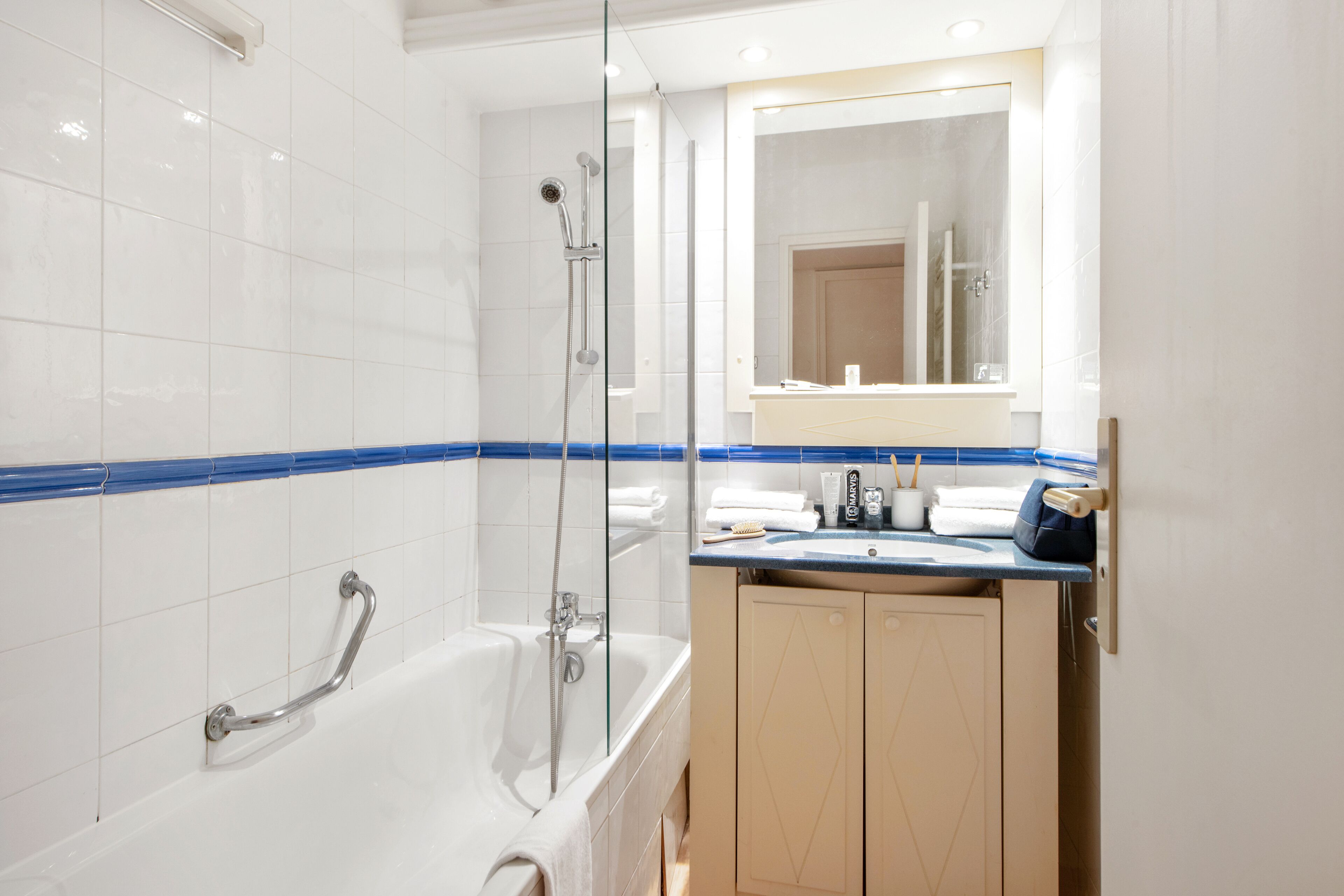 Een moderne badkamer met een badkuip, douche en wastafel met spiegel.