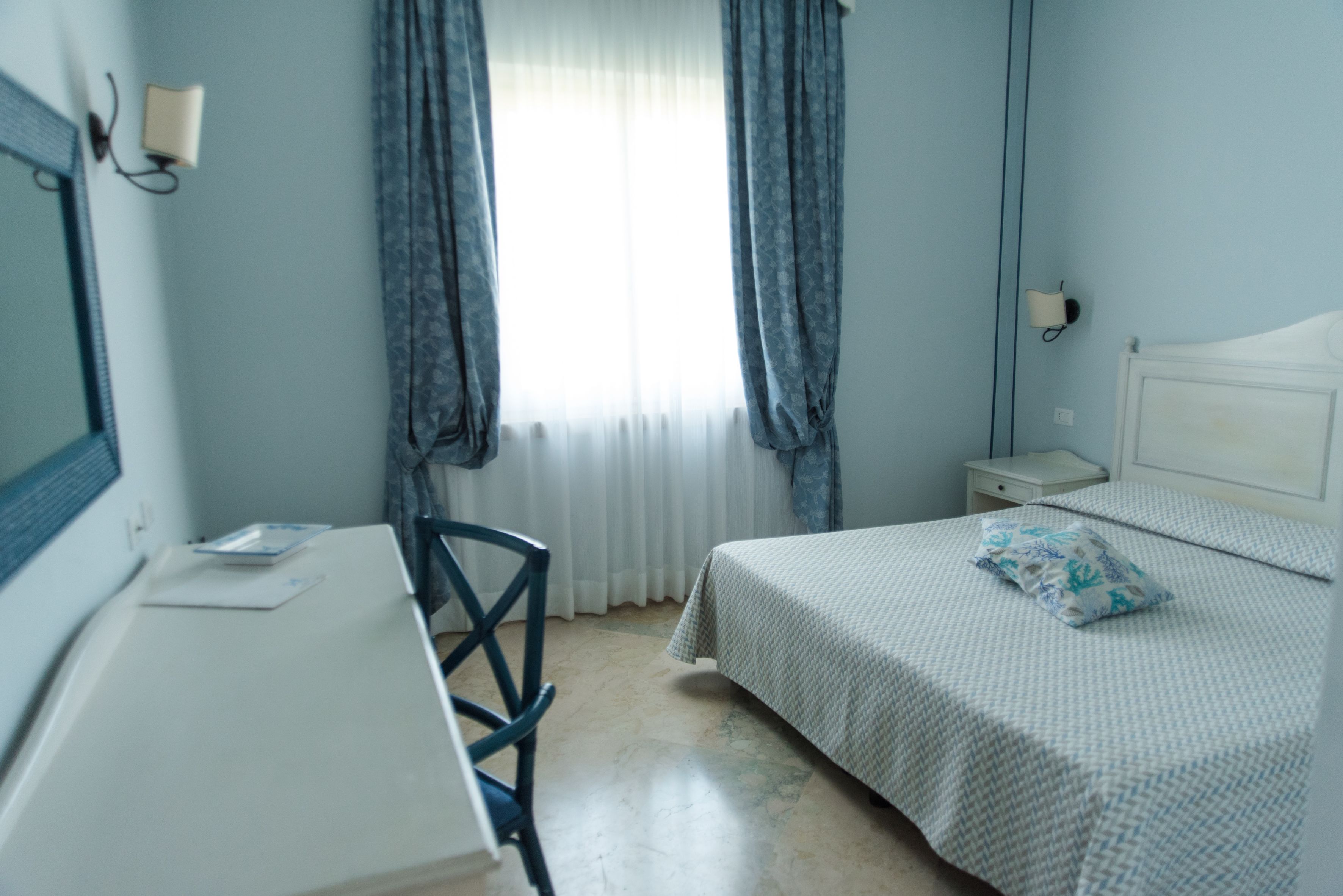 Un dormitorio con cama, escritorio y silla.