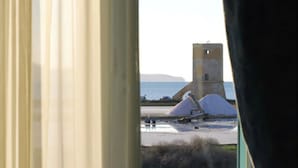 A view of a coastal area with a tower and tents. - Relais Antiche Saline (Paceco)