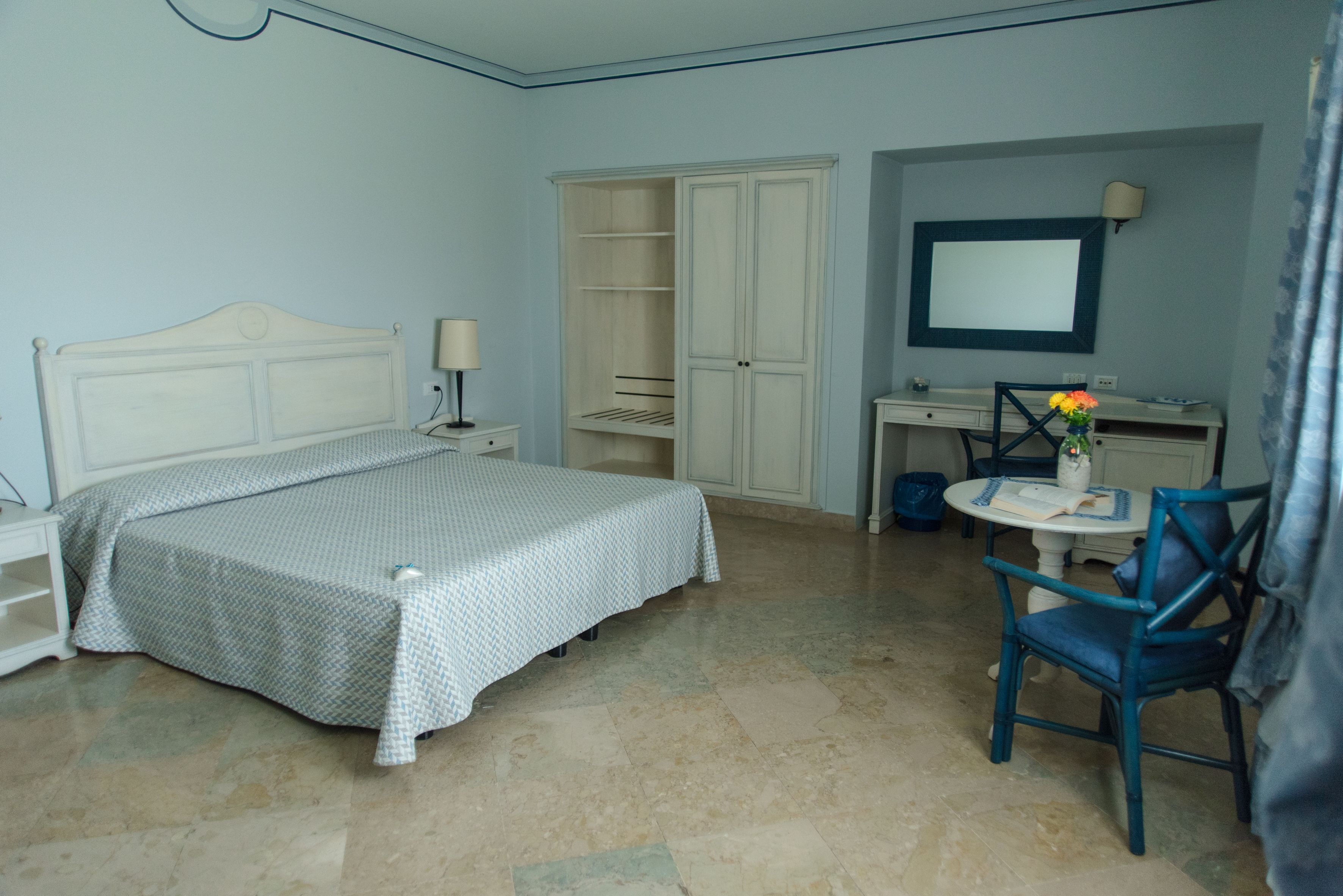 Ein Schlafzimmer mit einem Bett, einem Schreibtisch, einem Stuhl und einem Kleiderschrank.