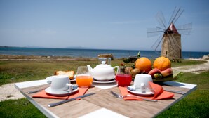 Una mesa de picnic con alimentos para el desayuno y un molino de viento al fondo.