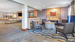 A spacious lobby with a reception desk, seating area, and a kitchen in the background. - Microtel Inn & Suites by Wyndham Lillington / Campbell Univ (Lillington)