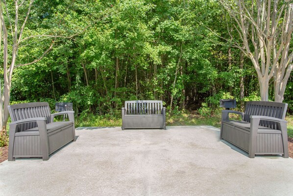 A bench with a backrest and armrests, placed on a concrete surface. - Microtel Inn & Suites by Wyndham Lillington / Campbell Univ (Lillington)