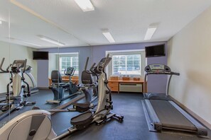 A gym with various exercise equipment, a treadmill, and a mirrored wall. - Microtel Inn & Suites by Wyndham Lillington / Campbell Univ (Lillington)