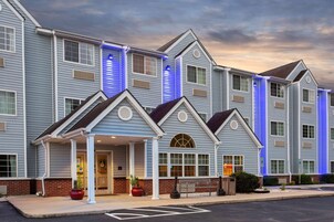 A multi-story hotel with a modern design, featuring a covered entrance and a brick facade.