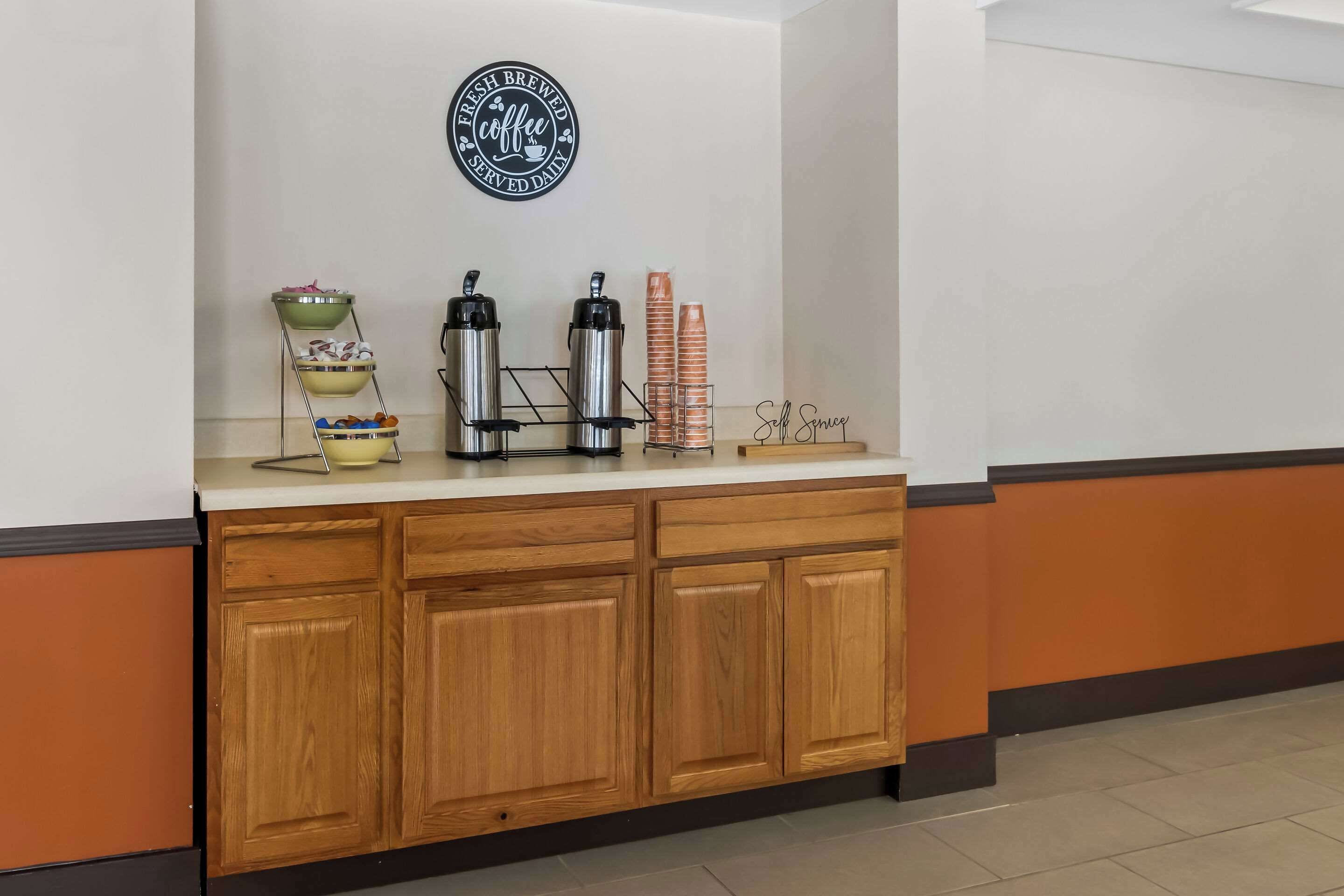 A counter with a coffee station, including a coffee machine, a kettle, and a coffee dispenser.