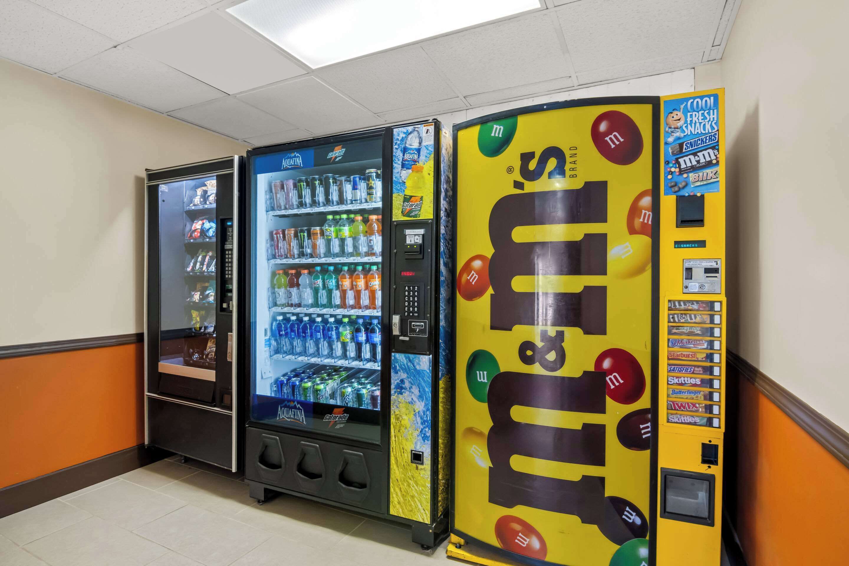 Three vending machines in a hallway.