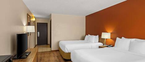 Habitación de hotel con dos camas, televisión, escritorio y puerta que da a otra habitación.