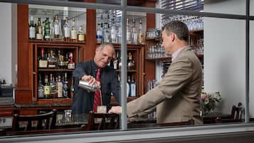 A bar area with a wooden cabinet stocked with liquor bottles and glasses.
