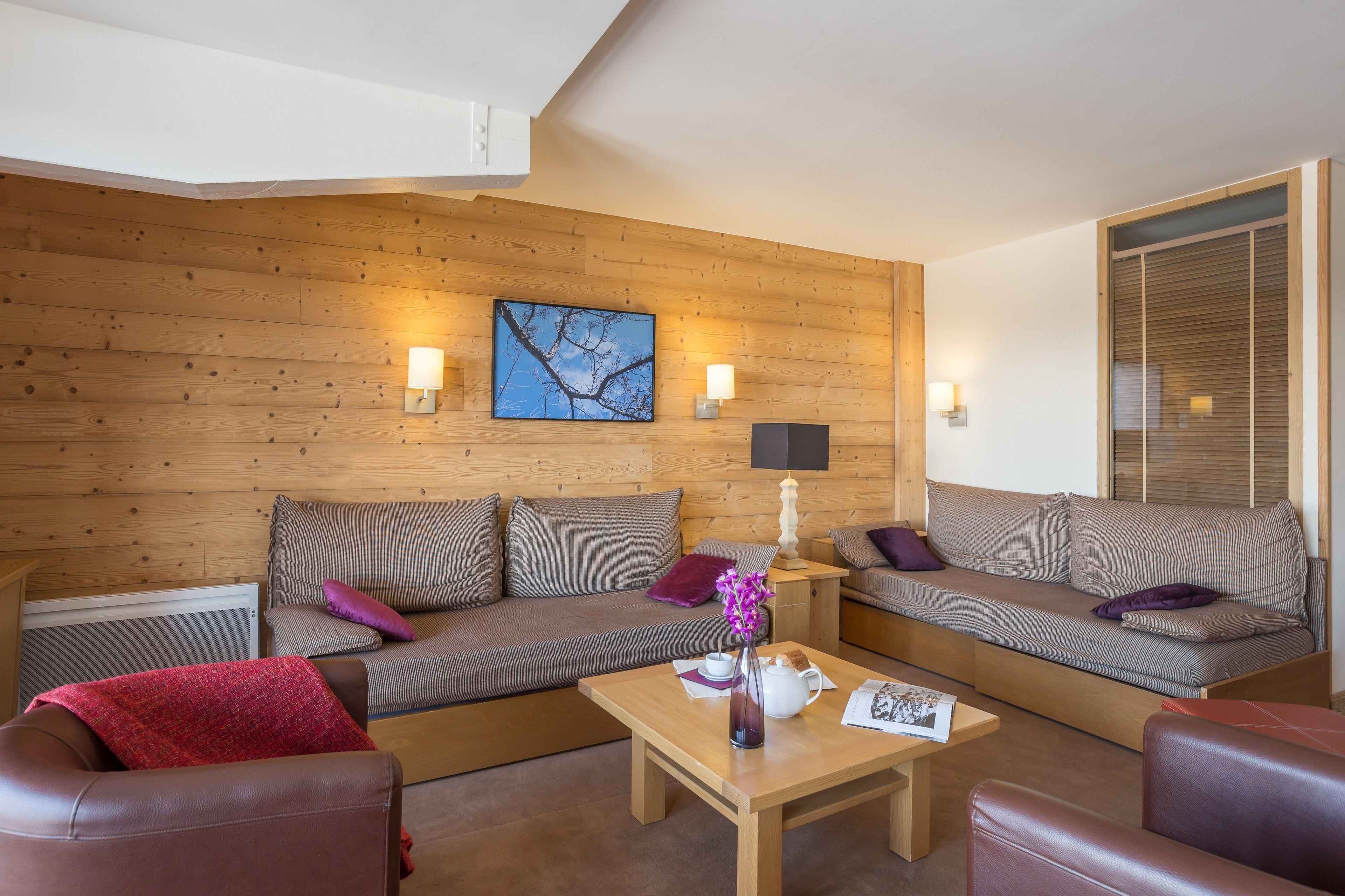 A cozy living room with two sofas, a coffee table, and a fireplace.