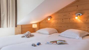 Cozy bedroom with two beds, a nightstand, and a reading light.