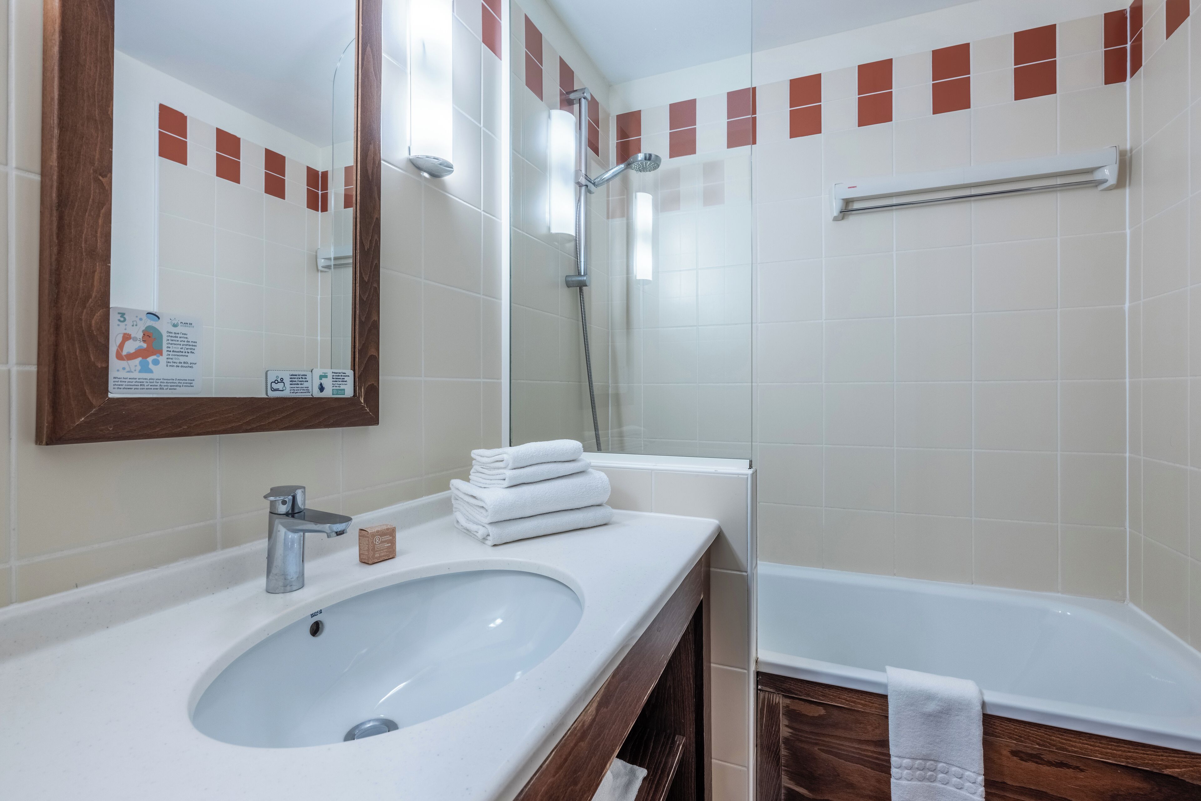 Une salle de bain équipée d’un lavabo, d’un miroir, d’une douche et d’une baignoire.