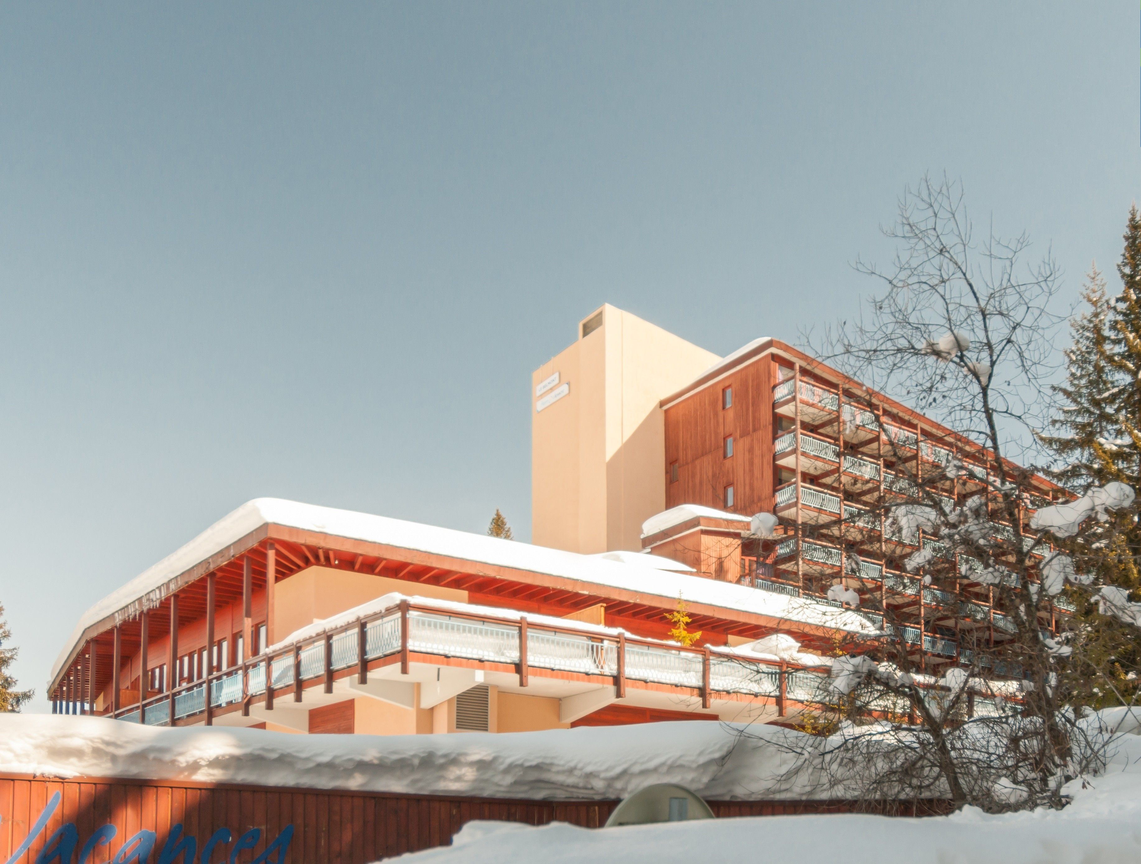 Un bâtiment moderne doté d’une façade en bois et d’un balcon.