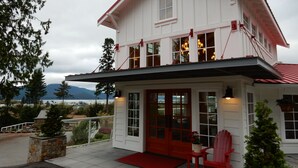 A two-story house with a balcony, a red door, and a view of the mountains. - Anacortes Ship Harbor Inn (Anacortes)