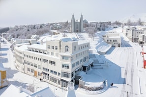 A multi-story building with a central courtyard, surrounded by snow-covered streets and buildings.