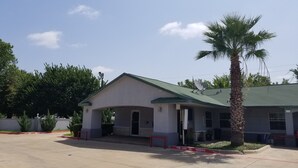 A building with a green roof and a covered entrance. - Haltom Inn (Haltom City)