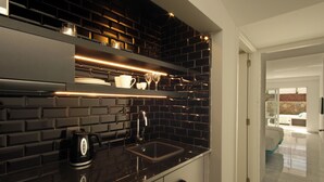 A modern kitchen with black tiled backsplash, stainless steel appliances, and a sleek countertop.